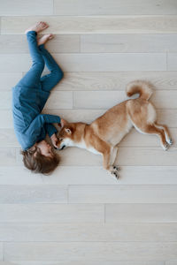 People and pets. top view of cute happy boy hugging his furry best friend shiba inu dog