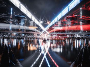 Illuminated bridge over river at night