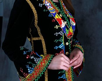 Midsection of woman standing by multi colored umbrella