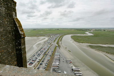 High angle view of road amidst field against sky