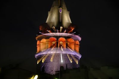 Low angle view of statue against illuminated building