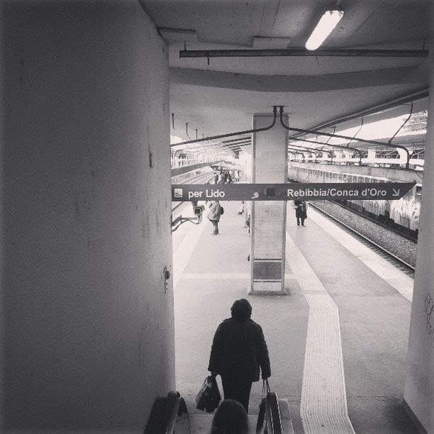 indoors, architecture, men, built structure, lifestyles, walking, rear view, person, railroad station, railing, standing, transportation, railroad station platform, ceiling, leisure activity, public transportation, full length, incidental people