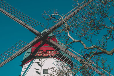 Low angle view of traditional windmill against clear blue sky