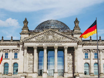 Low angle view of flags against sky in city