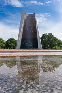 Low angle view of water tower by lake against sky