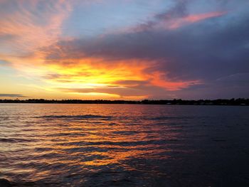 Scenic view of sea against dramatic sky during sunset