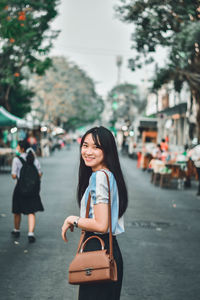 Portrait of smiling young woman in city