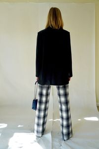 Rear view of woman standing against wall at home