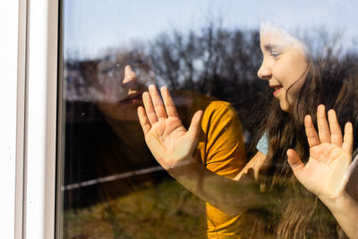 Midsection of woman looking through glass window