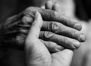 Close-up of female holding grandparent hand