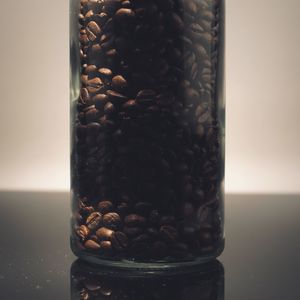 Close-up of coffee beans in glass jar on table