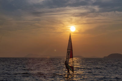 Sailboat on sea against sky during sunset