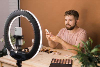 Young man using mobile phone on table