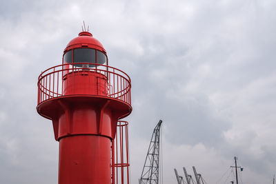 Low angle view of red lighthouse against sky