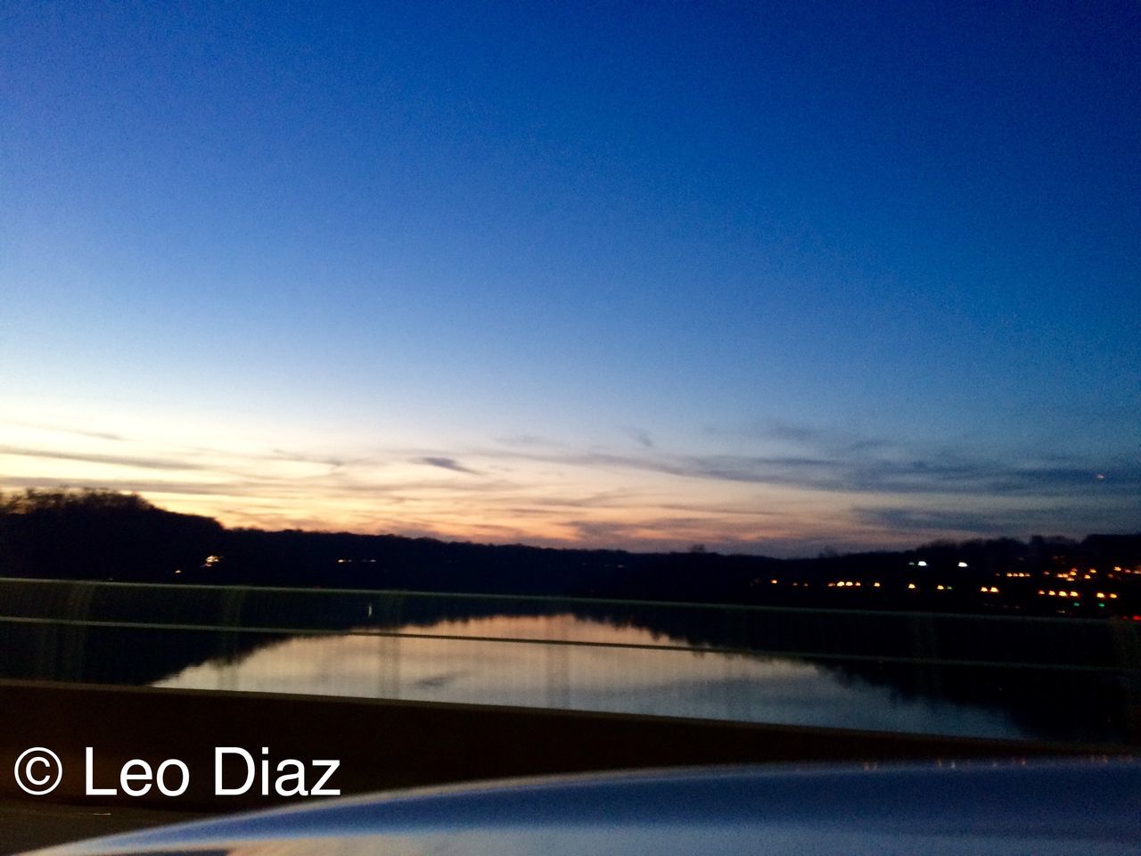 water, sky, river, illuminated, dusk, transportation, blue, copy space, text, lake, tranquility, tranquil scene, reflection, scenics, nature, road, clear sky, sunset, outdoors, railing