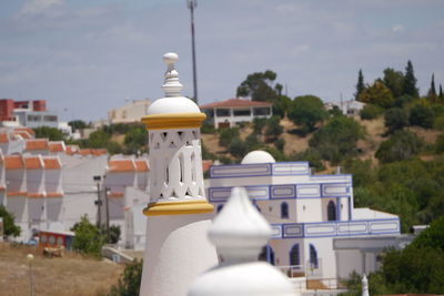 White building by trees against sky