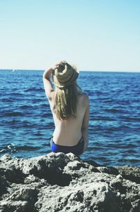 Rear view of man overlooking calm sea