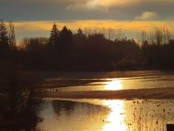 Scenic view of lake against sky during sunset