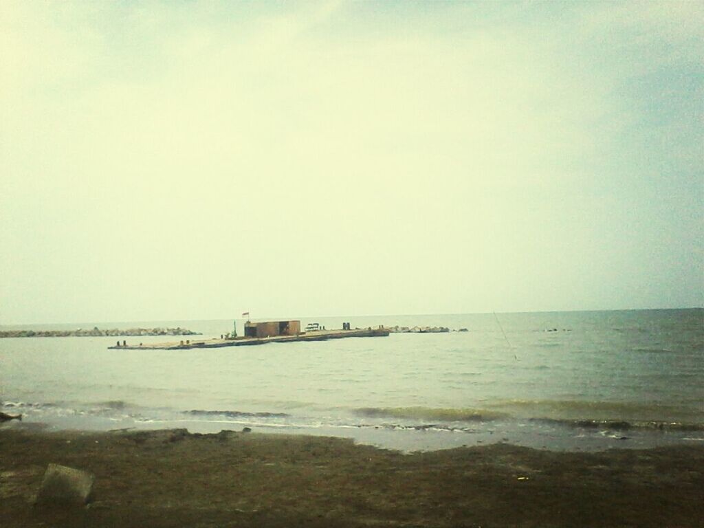 sea, water, horizon over water, beach, copy space, tranquil scene, tranquility, shore, scenics, clear sky, pier, sky, beauty in nature, nature, sand, built structure, idyllic, incidental people, outdoors, calm