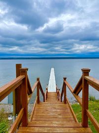 Wooden pier over lake against sky