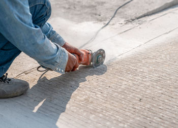 Grinder worker cuts concrete floor the electric tool,street construction work