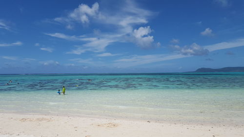 Scenic view of beach against cloudy sky