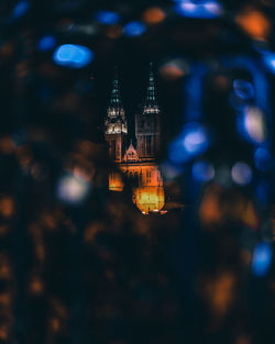 Close-up of illuminated lighting equipment hanging on building at night