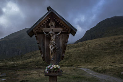 Low angle view of crucifix against mountains
