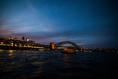 Illuminated bridge over city at night
