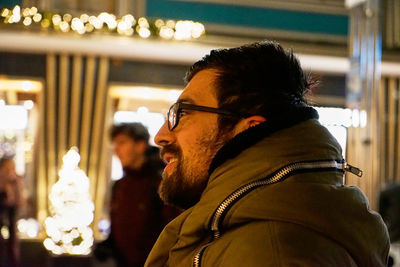 Portrait of young man looking at illuminated camera