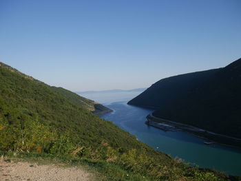 Scenic view of sea and mountains against clear sky