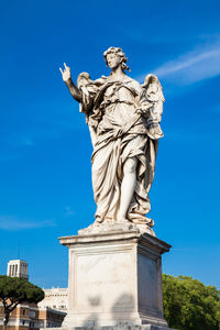 Low angle view of statue against blue sky