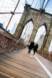 Tilt image of couple walking on brooklyn bridge