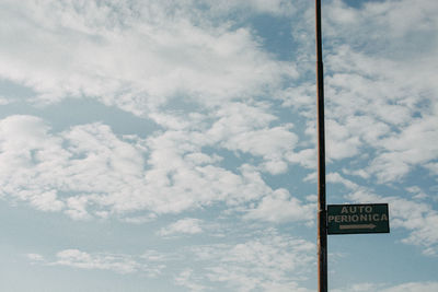 Low angle view of road sign against sky