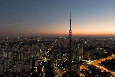 High angle view of city lit up against sky