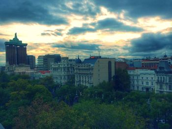 Buildings in city against cloudy sky