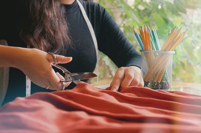 Close-up of fashion designer cutting fabric