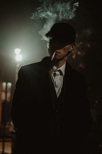 Young man smoking at night