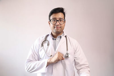 Portrait of man wearing eyeglasses against gray background