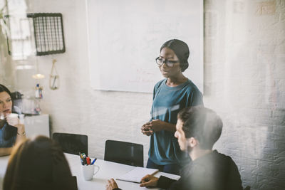 Creative businesswoman explaining colleagues during meeting in board room