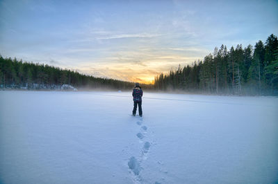 Full length of man walking on snow covered landscape