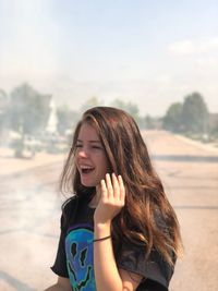 Smiling young woman standing on road