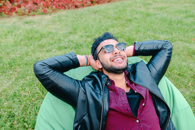 Smiling young man relaxing on bean bag outdoors