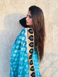 Young woman standing against wall