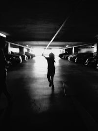 Rear view of silhouette man walking in illuminated underground