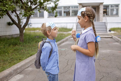 Side view of smiling girl standing outdoors