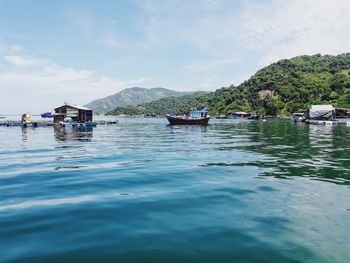 Houseboats moored in sea against sky