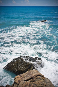 Scenic view of rocks in sea against sky