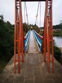 Footbridge over water against sky