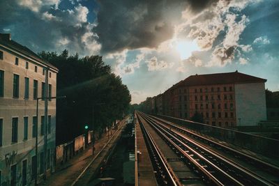 Railroad tracks in city against sky